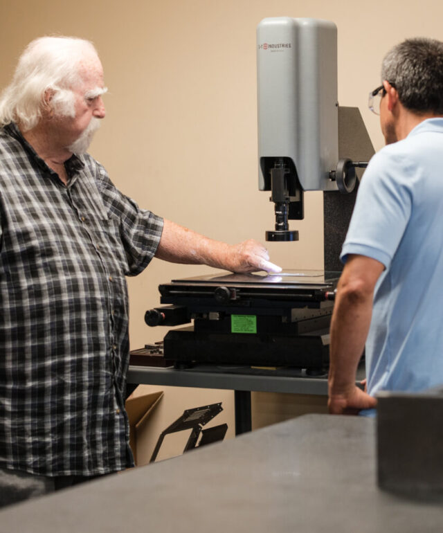 two adams campbell employees analyze a sample in the quality control room