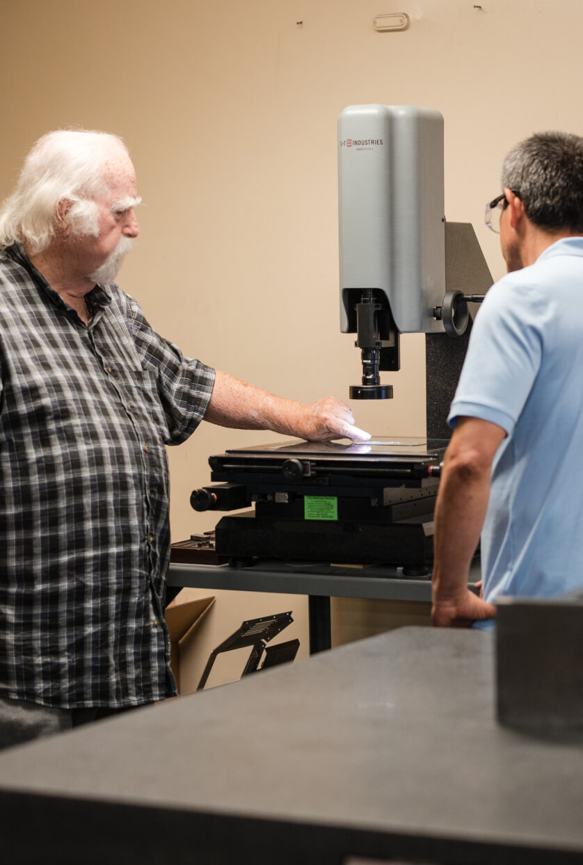 two adams campbell employees analyze a sample in the quality control room