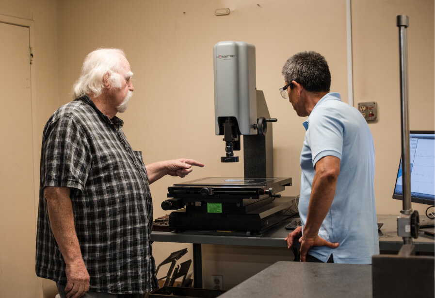 2 Adams Campbell employees using the vision inspection system