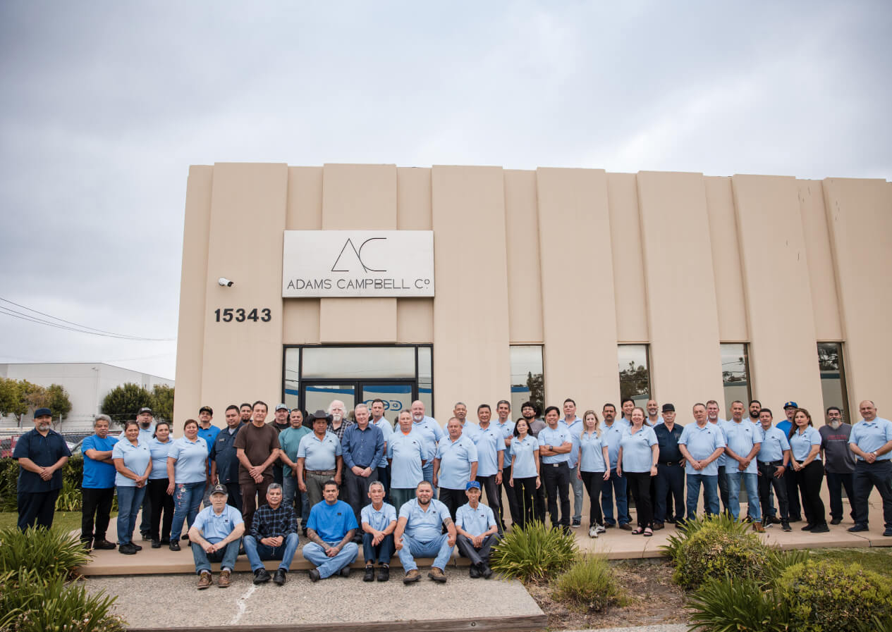 a photo of employees in front of the adams campbell co.metal production facility circa 2024